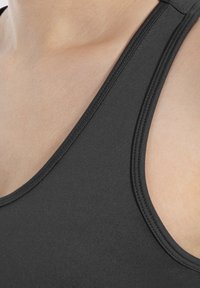 Camiseta sin mangas negra con una textura suave, tirantes anchos y un diseño de escote en V, con costuras en contraste a lo largo de los bordes.