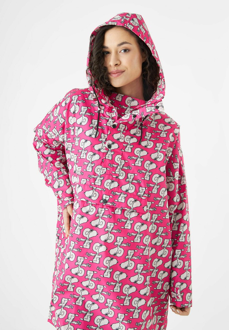 Roze waterdichte regenjas met een capuchon en patronen van cartoonfiguren. Losse pasvorm met een voorzak en trekaccenten.