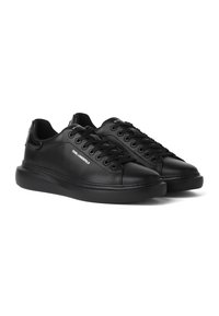 Ζευγάρι μαύρα δερμάτινα sneakers χαμηλού κόστους με μαύρα κορδόνια και το λογότυπο «Karl Lagerfeld» στο πλάι και στη γλώσσα, εμφανίζεται σε λευκό φόντο.