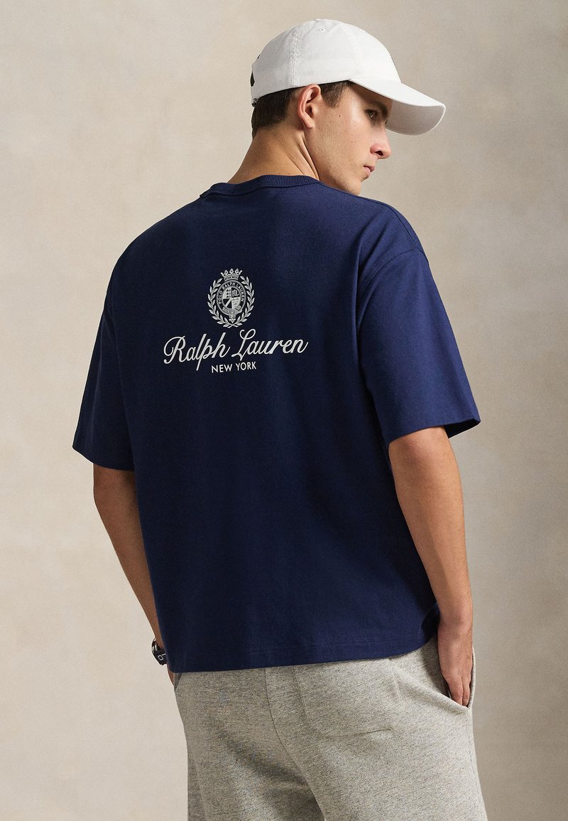 T-shirt en coton bleu marine à manches courtes, avec un logo circulaire et le texte « Ralph Lauren NEW YORK » en blanc au dos.