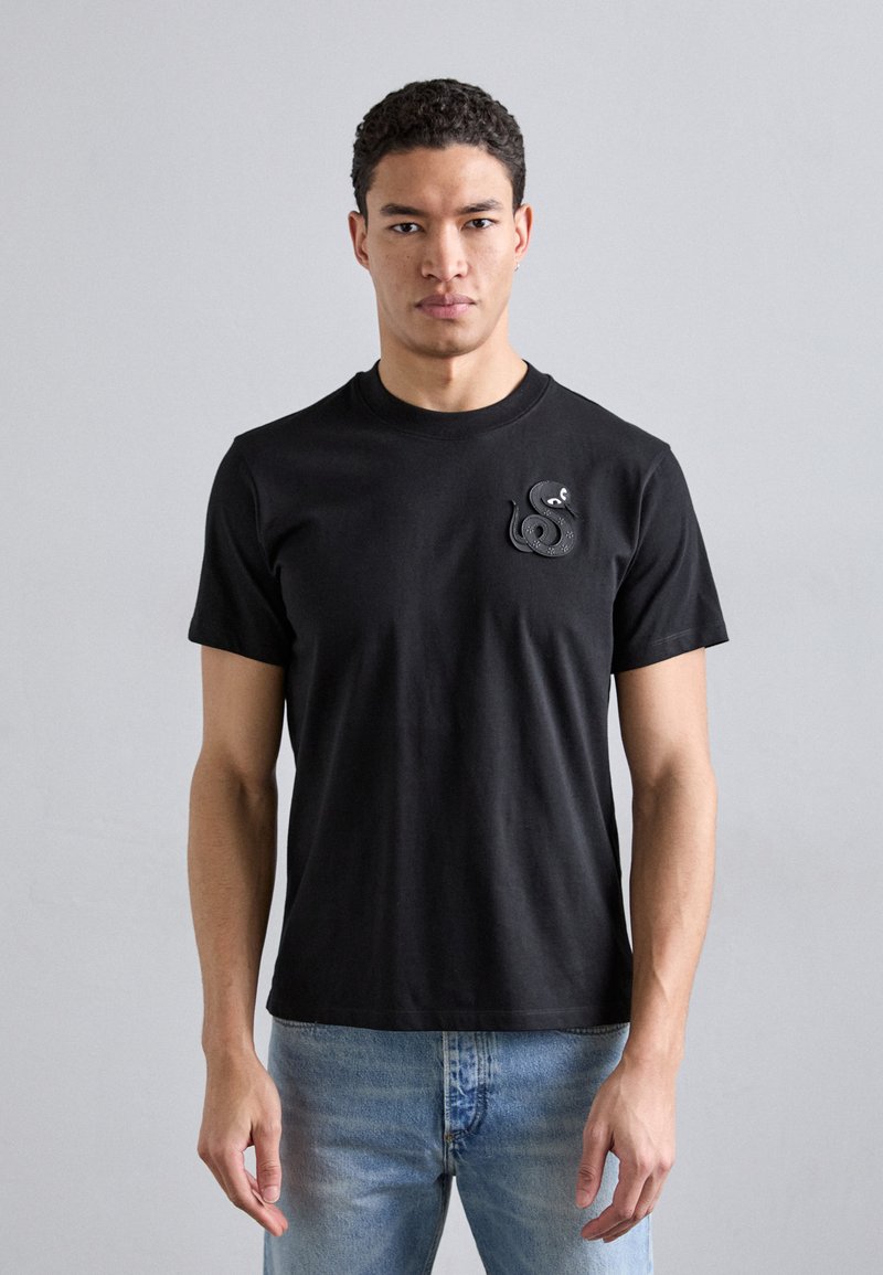 Zwarte katoenen t-shirt met ronde hals, korte mouwen, met een gestructureerd slanglogo op het linkerborstgebied.