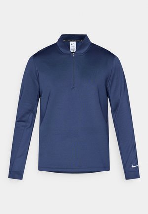 Polo à manches longues bleu marine avec demi-fermeture éclair, fabriqué à partir d'un tissu lisse. Il possède un col et un accent logo Nike sur la manche gauche.