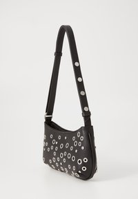 Borsa a spalla nera in pelle con dettagli in occhio di bue argentati e texture liscia, con una forma piatta e curva e tracolla regolabile.