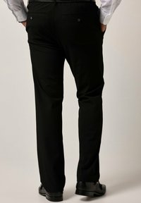 Schwarze, maßgeschneiderte Hose aus glattem Stoff mit geradem Bein, zwei Gesäßtaschen und dezenten Knopfdetails.