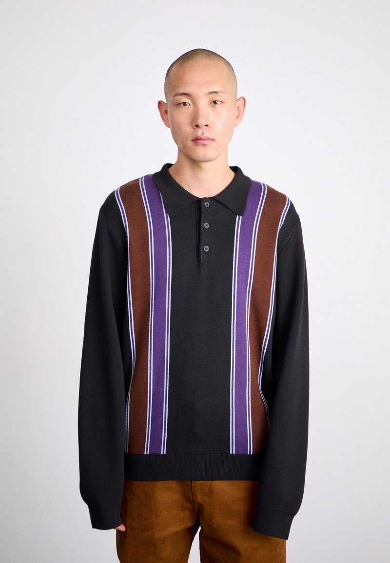Polo à manches longues en noir, avec des rayures horizontales marron, violet et bleu clair. Patte de boutonnage à trois boutons, texture tricotée.