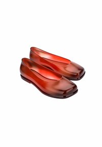Zapatos planos rojos transparentes con puntera redondeada, acabado brillante y bajo tacón, diseñados en un estilo simple y minimalista.