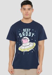 Marineblaues Baumwoll-T-Shirt mit einem Grafik eines Cartoon-Schweins in einem Raumanzug auf einer fliegenden Untertasse, mit dem Text "BESSTER PAPA IM UNIVERSUM" und Sternen.