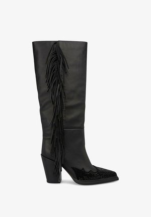 Czarne za kolano buty z frędzlami po zewnętrznej stronie, teksturowana cholewka, spiczasty nos ozdobiony detalami oraz masywny obcas.