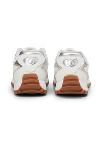 White athletic shoes with a textured, light gray upper, silver accents, and a rubber outsole with a brown tread pattern.