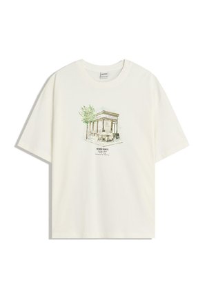 T-shirt color crema con un'illustrazione stampata di un caffè circondato da fogliame verde e la scritta "Niente più rimpianti" sotto il design.
