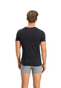 Tricou negru din bumbac cu guler rotund, mâneci scurte și un design ajustat, asociat cu boxeri gri. Textură netedă, detalii minime.