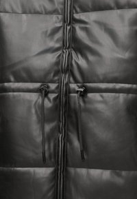 Czarna kurtka puchowa o błyszczącej powierzchni, z zamkiem błyskawicznym z przodu, dwoma regulowanymi sznurkami oraz pikowanymi sekcjami dla dodatkowej tekstury.