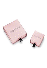 Scatole di cartone rosa con motivi a cuore dorati, una grande e una piccola, ciascuna con un nastro nero per tirare e il testo "GLANZSTÜCKE MÜNCHEN".