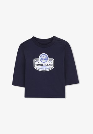 T-shirt à manches longues bleu marine en coton avec un logo Timberland blanc et un graphique d'arbre, doté de deux boutons-pression à l'épaule.