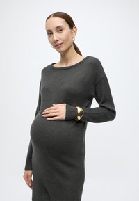 Σκούρο γκρι πλεκτό φόρεμα εγκυμοσύνης με φαρδιά λαιμόκοψη και μακριά μανίκια, με ριμπ μανσέτες και λεία υφή. Διακοσμητικό χρυσό βραχιόλι μανσέτα.