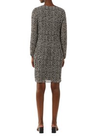 Robe à imprimé léopard avec des manches longues, silhouette ajustée, taille élastique et tissu léger et texturé. Longueur mi-cuisse avec un décolleté arrondi.