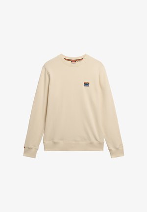 Beige Crewneck-Sweatshirt aus weichem Stoff. Verfügt über lange Ärmel und ein kleines, mehrfarbiges Berg-Patch auf der linken Brust.