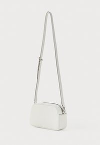 White leather crossbody bag with a rectangular shape, smooth texture, an adjustable strap, and a silver zipper detail.
