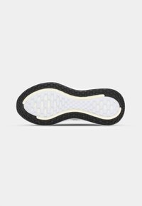 Semelle d’une chaussure de course avec une bande de roulement extérieure noire et une section intérieure blanche présentant des motifs de grip rectangulaires sur un fond uni.