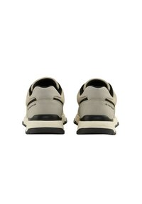 Zapatillas deportivas grises claras con parte superior texturizada, acentos negros y una suela de goma resistente. Presentan un logo en el talón y un diseño de malla transpirable.