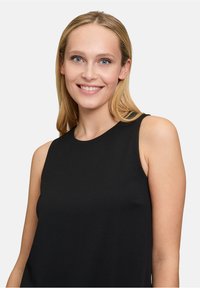 Czarny bezrękawnik z okrągłym dekoltem; gładki, lekki materiał; prosty fason; brak widocznych wzorów lub ozdób.
