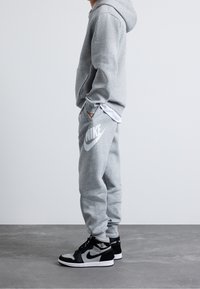 Nike Sportswear CLUB UNISEX - Träningsbyxor - dark grey heather/base grey/white