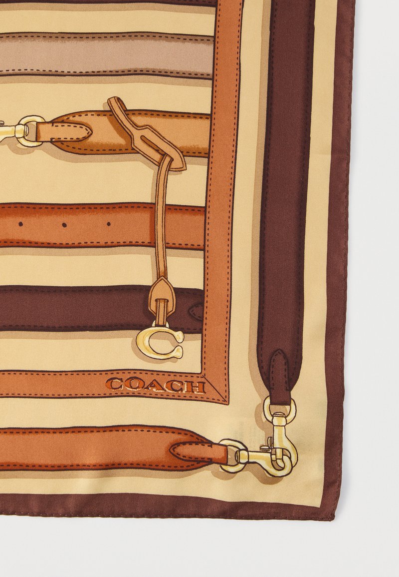 Seidenschal mit einem gestreiften Muster in warmen Farbtönen, versehen mit grafischen Akzenten aus Lederbändern und goldenem Beschlag. Das Logo ist sichtbar.