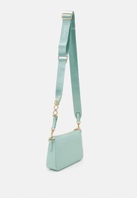 Borsa a tracolla verde menta con superficie texturizzata, hardware dorato e tracolla regolabile con dettaglio del logo. Forma rettangolare.