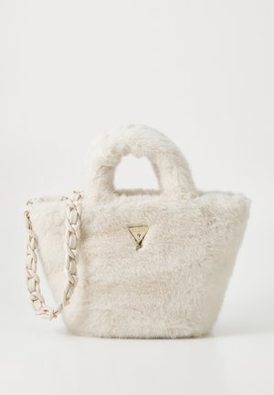 Sac en fausse fourrure de couleur blanc cassé avec un logo doré triangulaire, deux poignées courtes et une bandoulière tressée. Surface texturée.