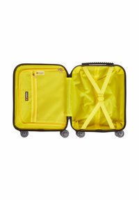 Hårdkapslad resväska med svart yttre och ljusgul inredning, utrustad med ett meshfack, korsremmar och fyra rullande hjul för smidighet.