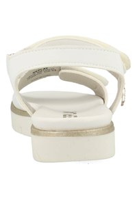 Witte sandalen met verstelbare banden, een gevoerd voetbed en een zool met gouden accenten. Gladde materiaal met minimale stikdetails.