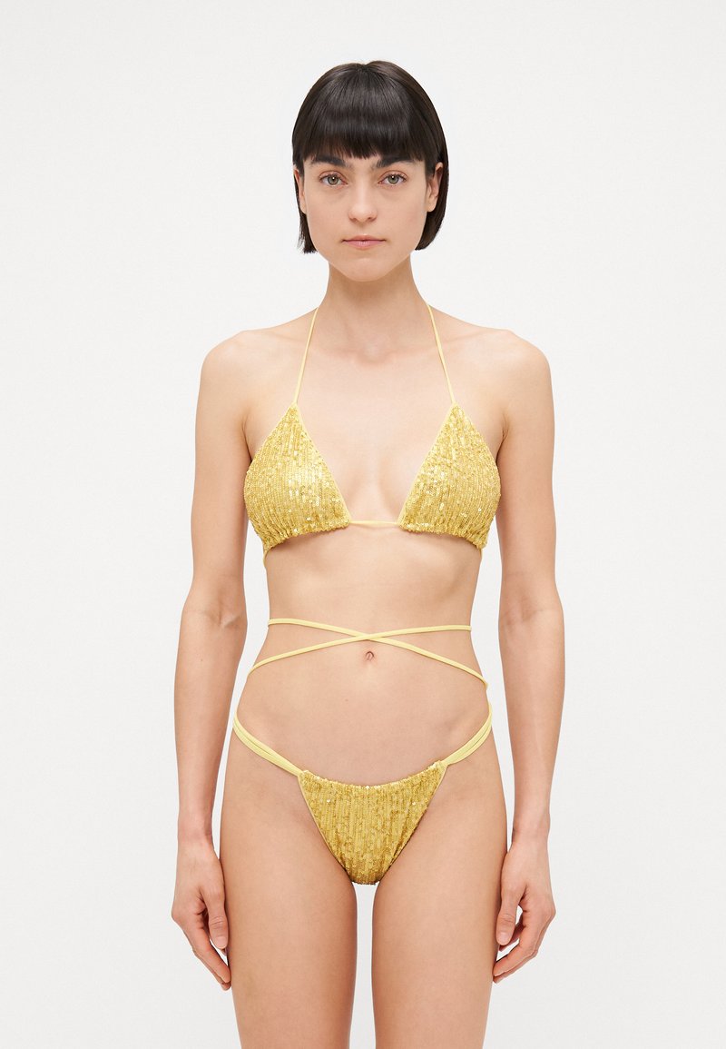 Conjunto de bikini amarillo con lentejuelas que presenta un top en forma de triángulo con tirantes finos y una parte inferior de talle bajo con lazos envolventes, resaltando los adornos texturizados.