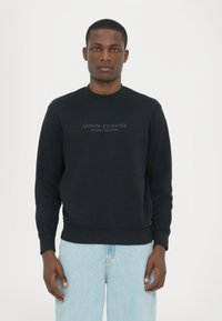 Zwarte sweatshirt van een katoenmix, met een ronde hals en geribbelde boorden. "Armani Exchange Milano/New York" gedrukt op de voorkant.