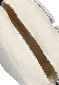 Wit schapenleren rugzak interieur met twee ritscompartimenten, voorzien van zilveren hardware en een warme bruine voering. Gevoelde buitenkant.