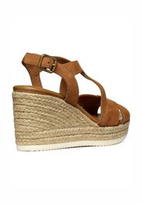 Sandali con zeppa in suede marrone, con suola in juta stile espadrilles. Presentano cinturini incrociati e una fibbia dorata. Design a punta chiusa.