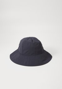 Chapéu tipo balde azul marinho feito de tecido leve, com uma aba larga e plana, costuras verticais e um orifício de ventilação de cada lado.