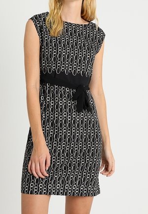 Robe noire avec un motif de chaîne circulaire blanche, des manches courtes et une silhouette ajustée, agrémentée d'une ceinture nouée à la taille.