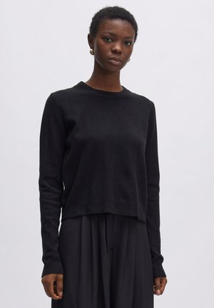 Schwarzer Wollpullover mit rundem Ausschnitt, langen Ärmeln und cropped Fit. Glatte Textur mit gerippten Bündchen und Saum.
