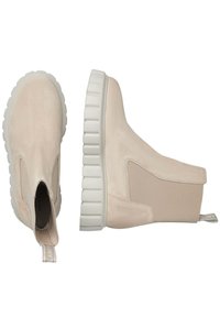 Beige ankelstövlar med mocka-textur och elastiska sidopaneler, med en tjock vit gummisula med ett mönster av ribbor.