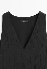 Schwarzes ärmelloses V-Ausschnitt-Kleid mit zerknittertem, strukturiertem Stoff und Massimo Dutti Etikett im Nackenausschnitt.
