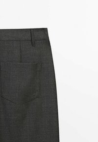 Pantalon en tissu gris foncé avec une poche arrière et un passant de ceinture, présenté sur fond blanc.