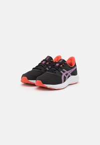 Chaussures de sport noires avec des accents roses, dessus en maille, semelle rembourrée et lacets. Elles possèdent une semelle intermédiaire blanche et une semelle extérieure texturée orange.
