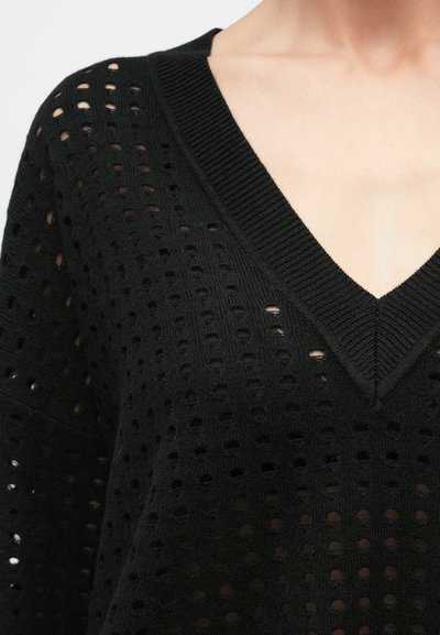 Čierny pletený sveter s výstrihom do V, so štruktúrovaným vzorom otvorených dierok a rebrovanými detailmi na krku a rukávoch.