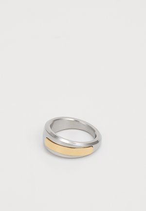 Metal ring featuring a silver band with a horizontal gold accent. The design is smooth and rounded, showcasing a modern, minimalist style.