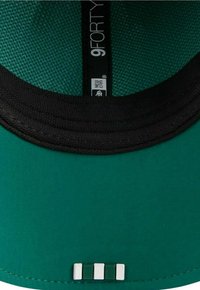 Grüne Kappe mit schwarzem Schirm, ausgestattet mit einem strukturierten Innenfutter und einem kleinen metallischen Logo. Drei weiße und grüne Akzente am unteren Rand.