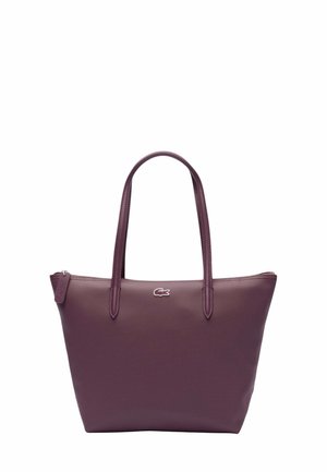 Sac fourre-tout carré en simili cuir texturé violet profond. Dispose de deux longues poignées et d'un petit logo sur le devant. Fermeture éclair sur le dessus.