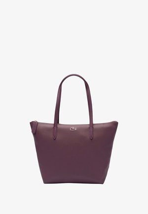 Square tote bag in textured deep purple faux leather. Features two long handles and a small logo accent on the front. Zippered top closure.