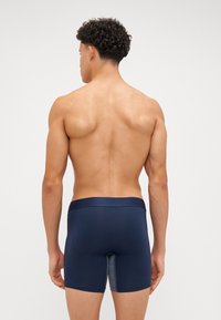 Navy blue men's boxer briefs with a smooth texture and a contrasting gray panel at the front. Elastic waistband with branding detail.