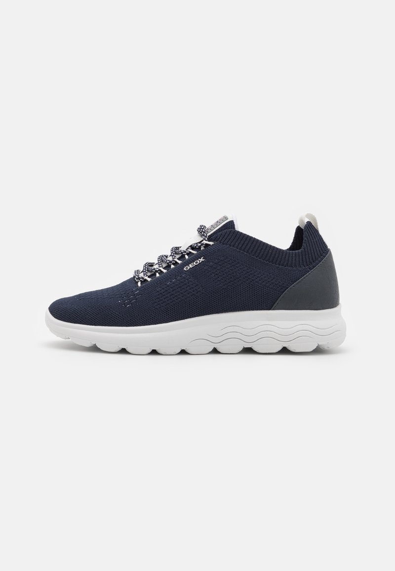 Mörkblå mesh-sneakers med vit gummisula, texturerade accenter och mönstrade snören. Har en vadderad krage och logotypdetalj på sidan.