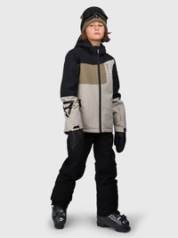 Bambino che indossa una giacca da sci color bloc, pantaloni da neve neri, guanti, berretto, occhiali da sci e scarponi da sci, in piedi di fronte a uno sfondo neutro.